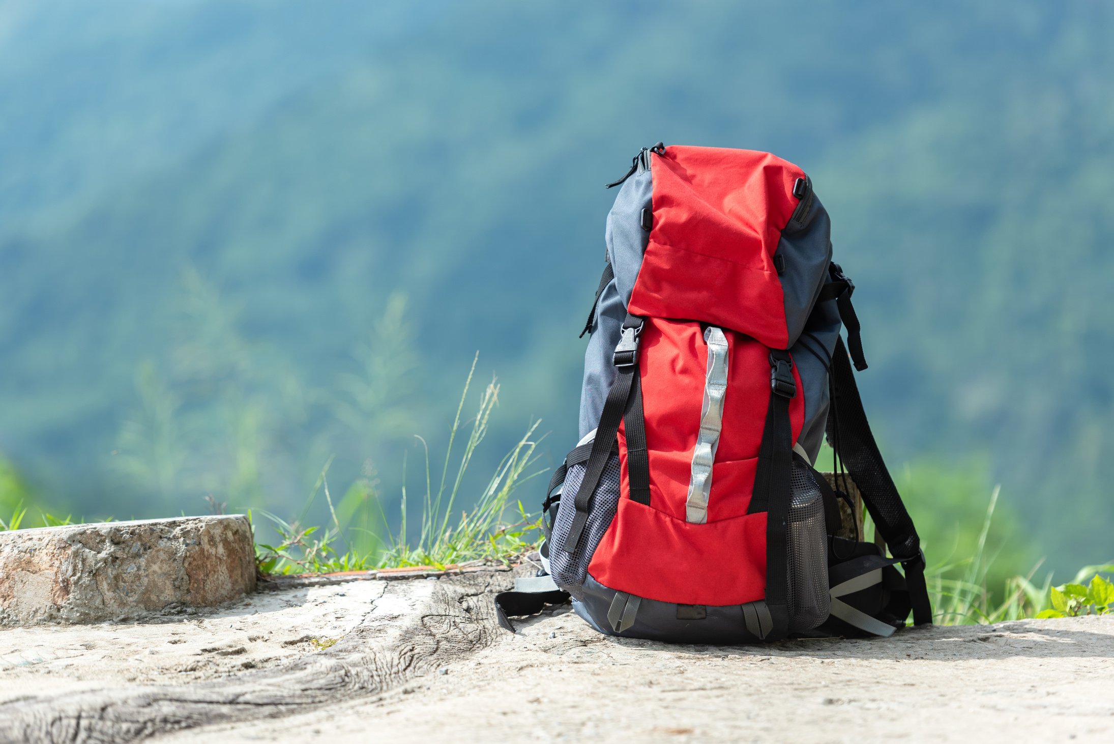 Hiking backpack travel gear on mountain. Items include hiking for travel